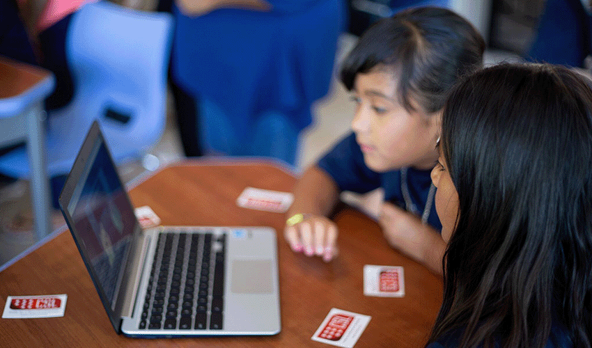 Two children using a laptop